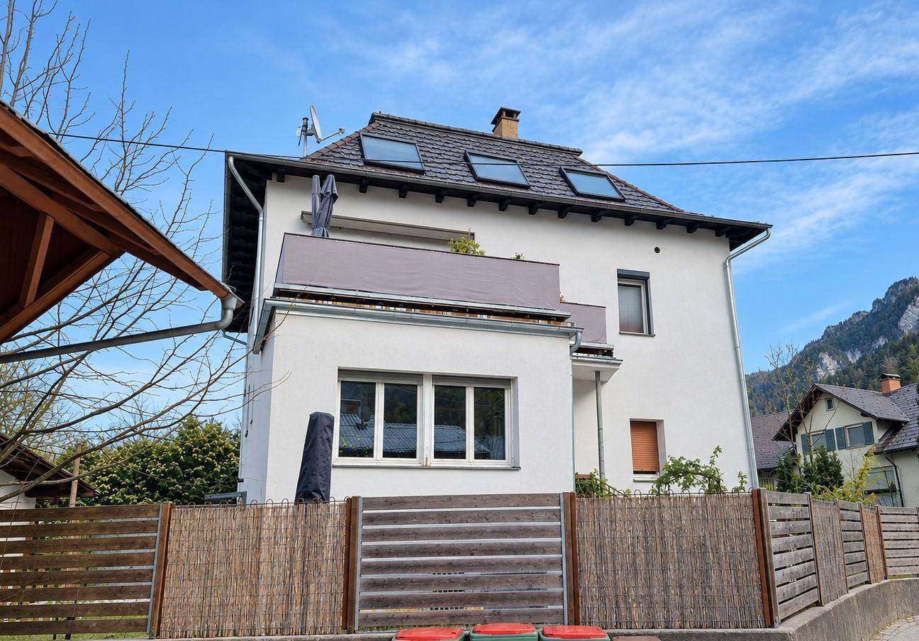 Rückseite des Hauses mit Balkon, Dachfenstern und Blick auf die umliegende Natur.