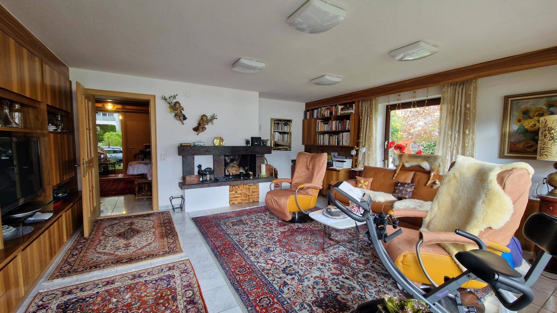 Wohnzimmer mit Kamin, Holzeinbauten und traditioneller Einrichtung, ideal für gemütliche Abende.