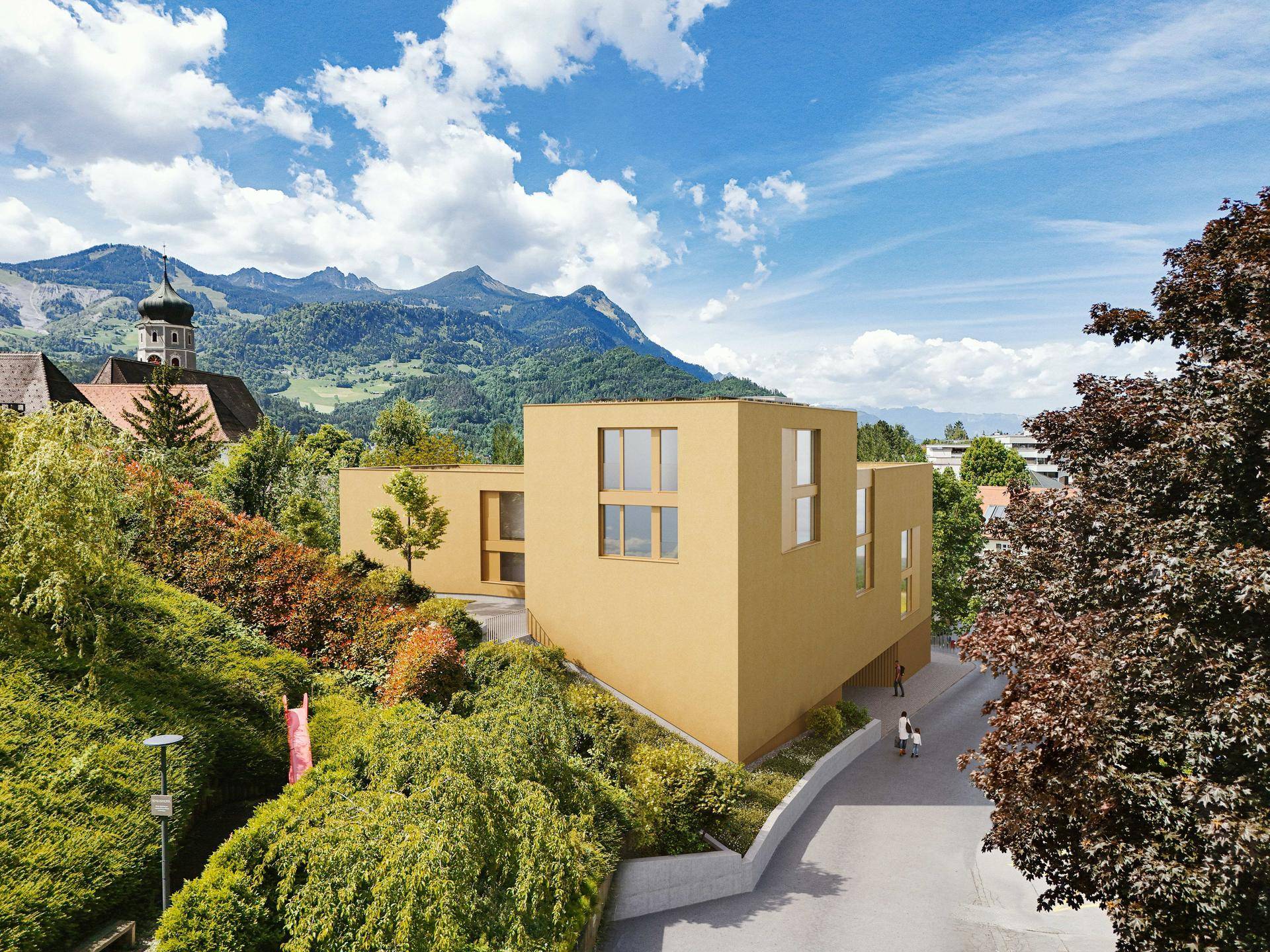 Modernes Gebäude mit gelber Fassade, umgeben von üppiger Vegetation und Bergpanorama im Hintergrund.