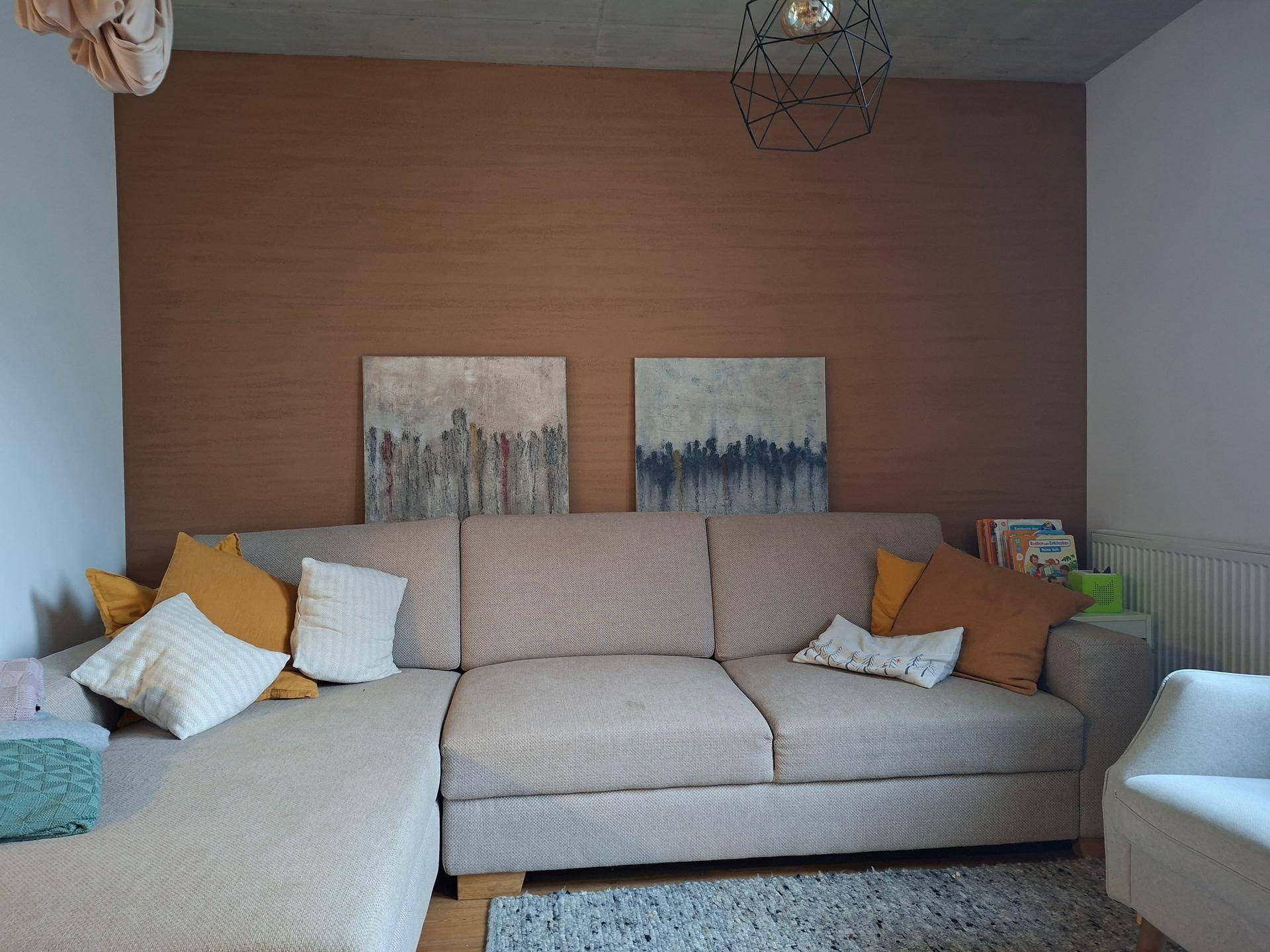 Gemütliches Wohnzimmer mit großem Ecksofa, Akzentwand und moderner Dekoration.