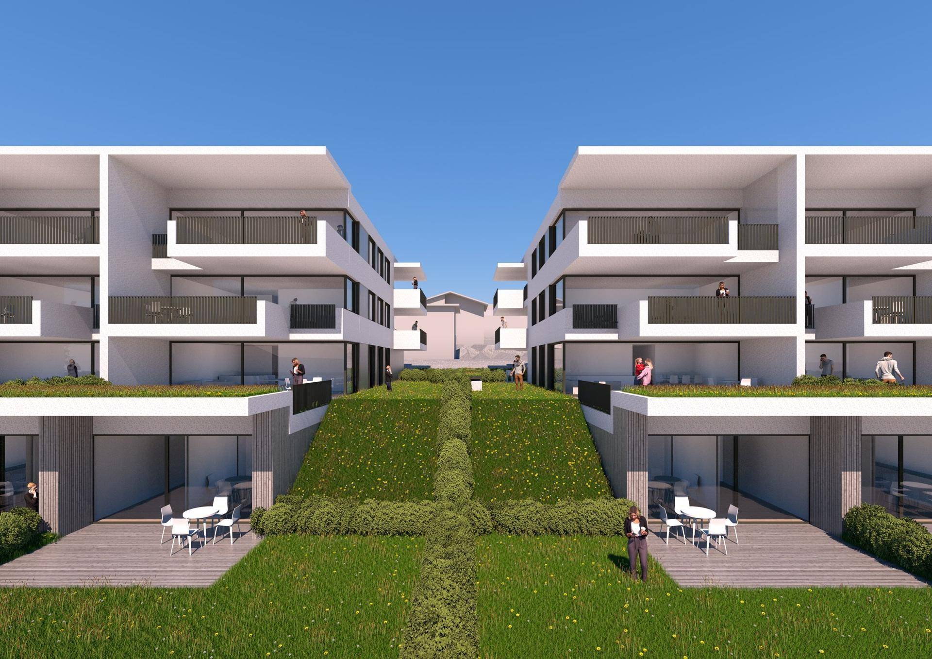 Innenhof der modernen Wohnanlage mit begrünten Flächen und privaten Terrassenbereichen zwischen den Gebäuden.