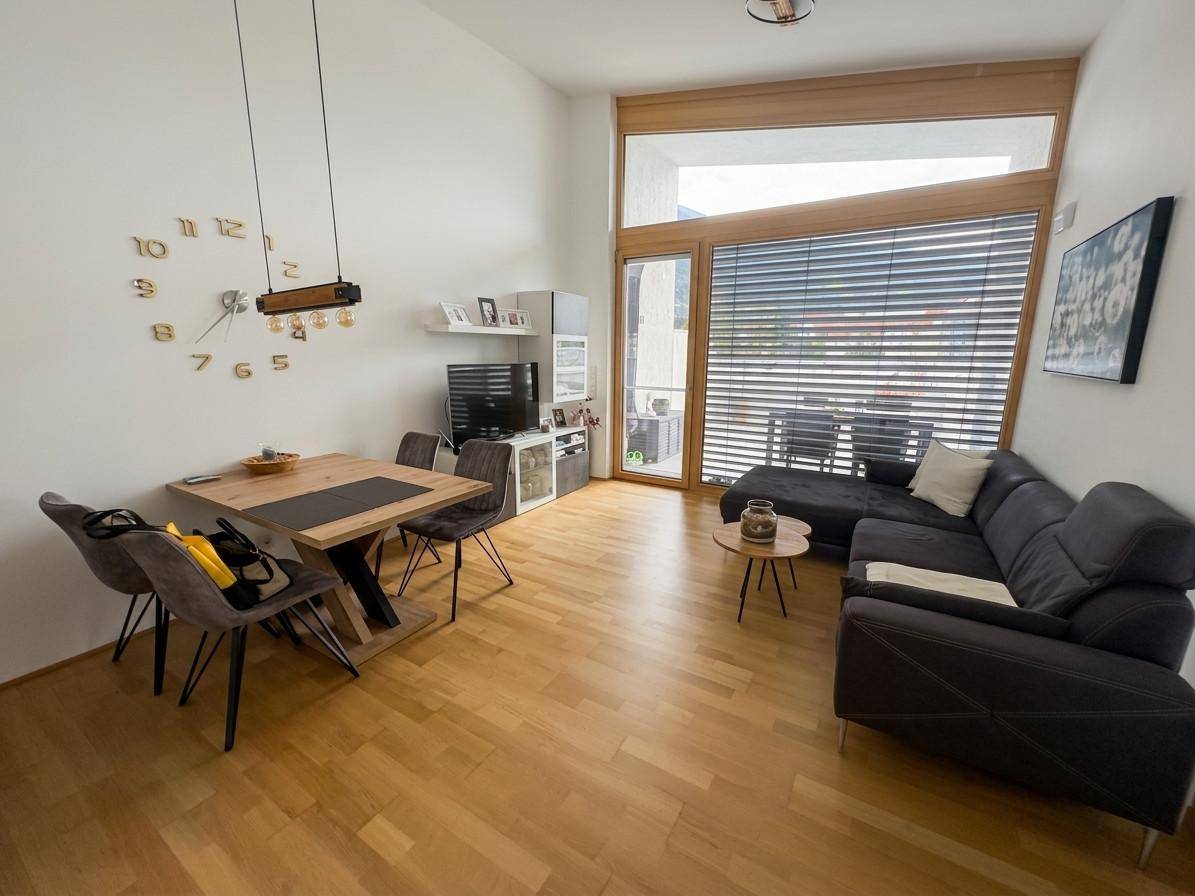 Heller Wohn- und Essbereich mit Holzboden, moderner Einrichtung und Zugang zur Terrasse.