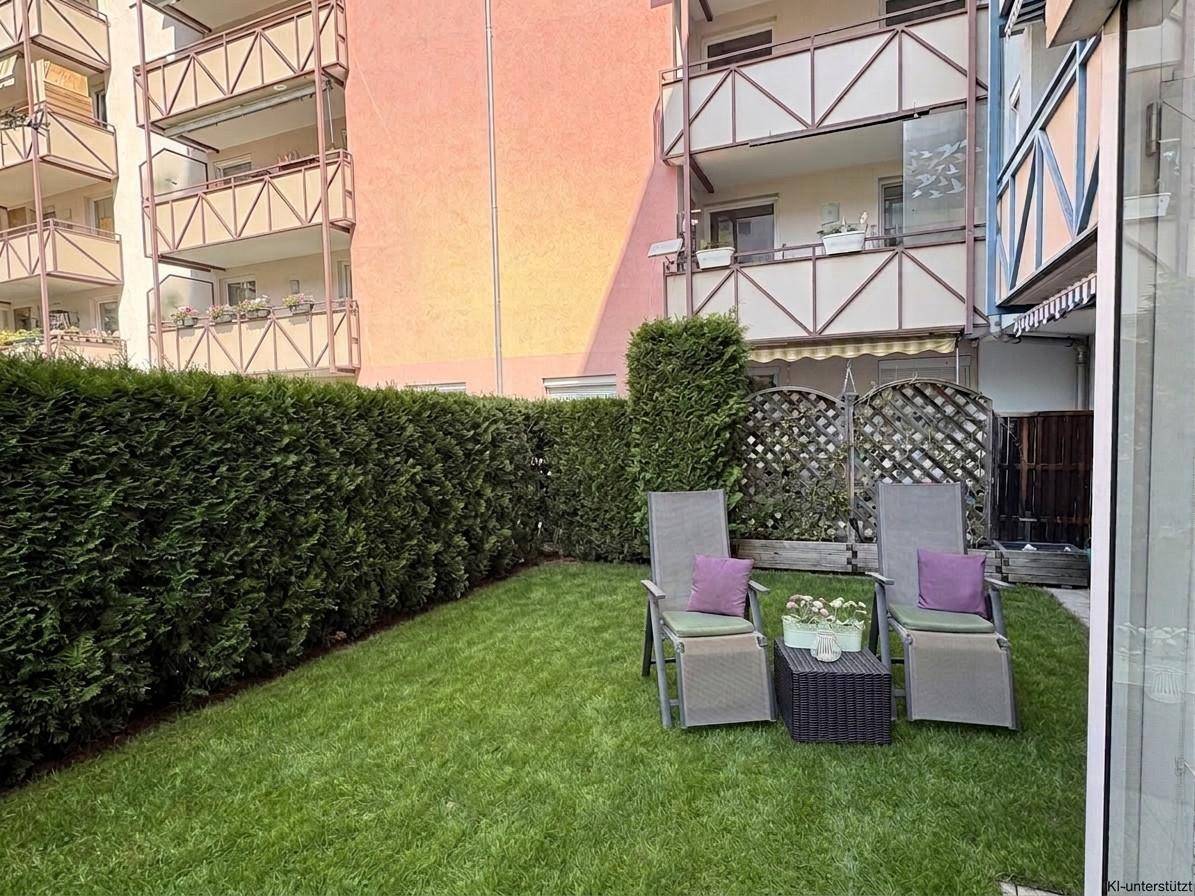 Gepflegter Gartenbereich mit Rasenfläche, Liegestühlen und einer hohen Hecke für Privatsphäre.