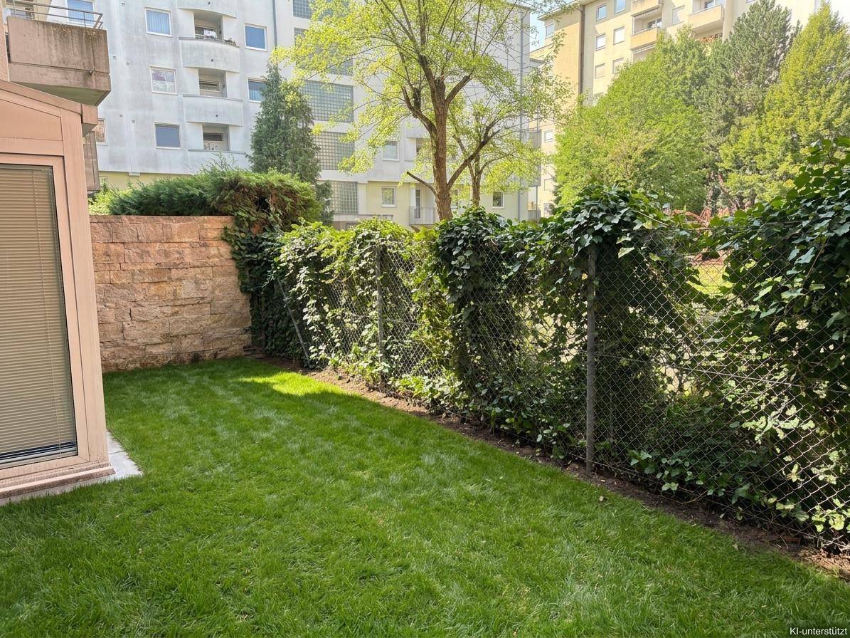 Grüner Gartenbereich mit Rasenfläche und einer mit Efeu bewachsenen Zaunwand.