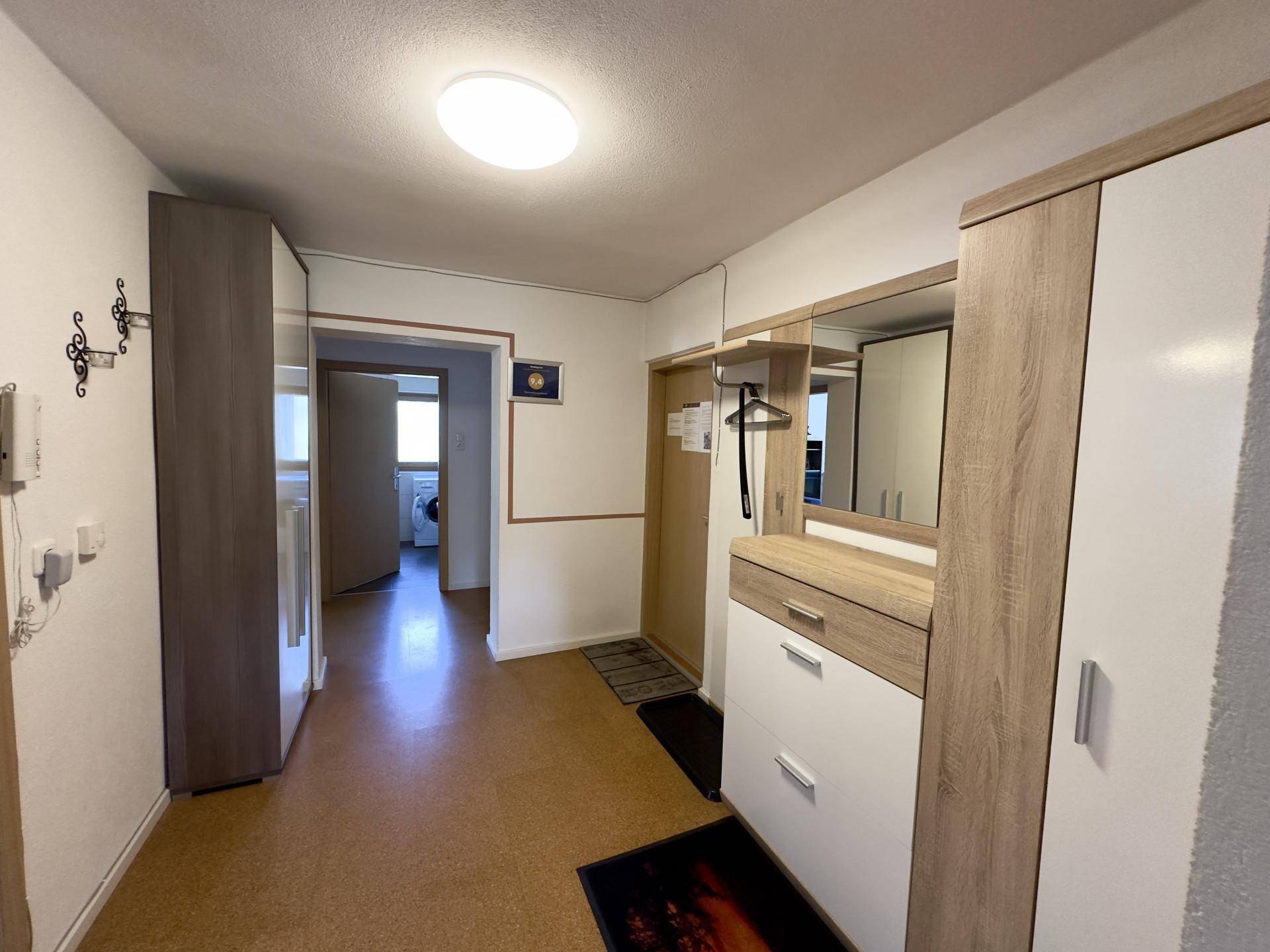 Heller Flur mit Garderobe, Spiegel und praktischem Stauraum für Kleidung und Schuhe.