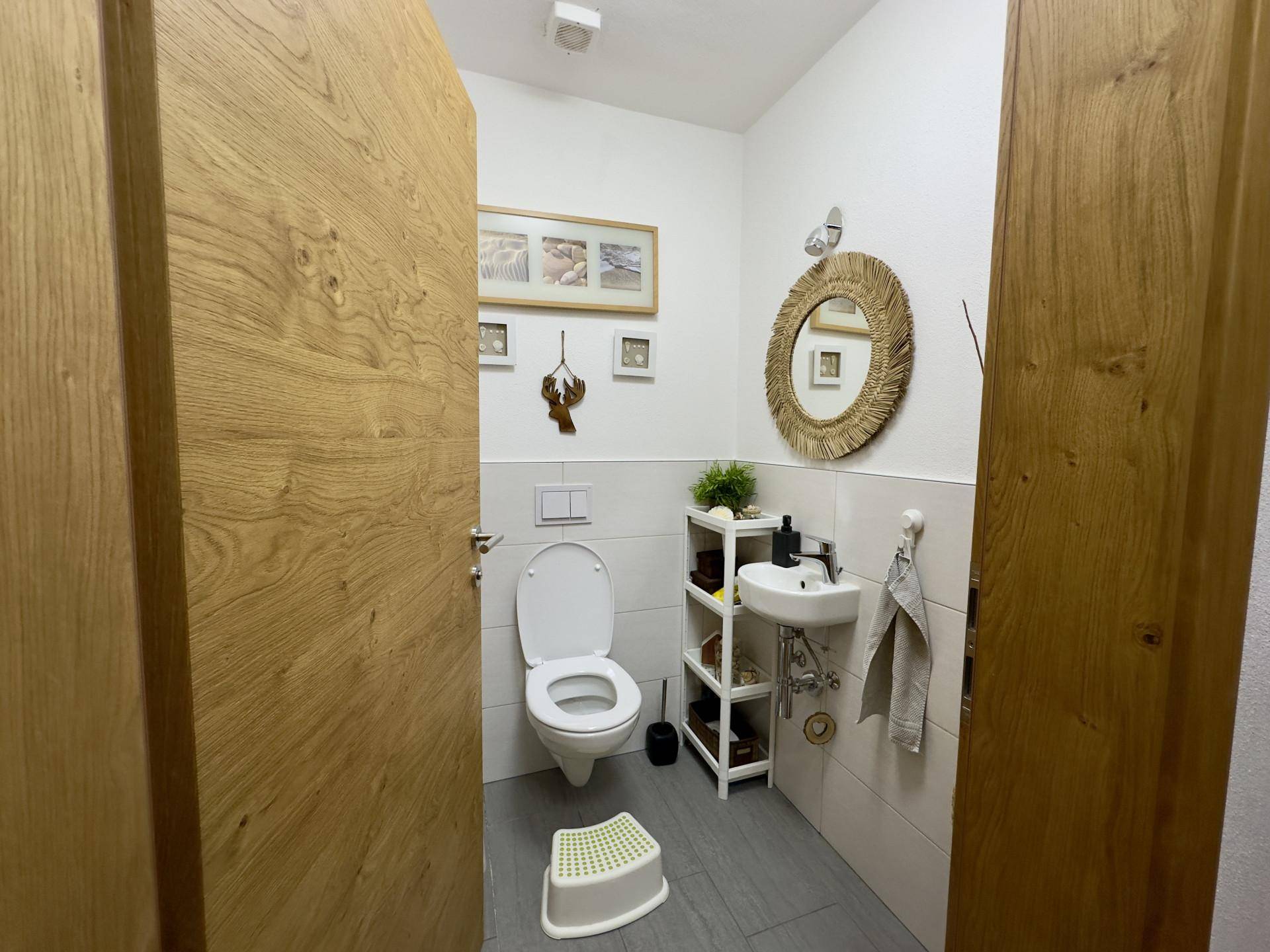 Kleines Gäste-WC mit wandhängender Toilette und modernem Waschbecken.
