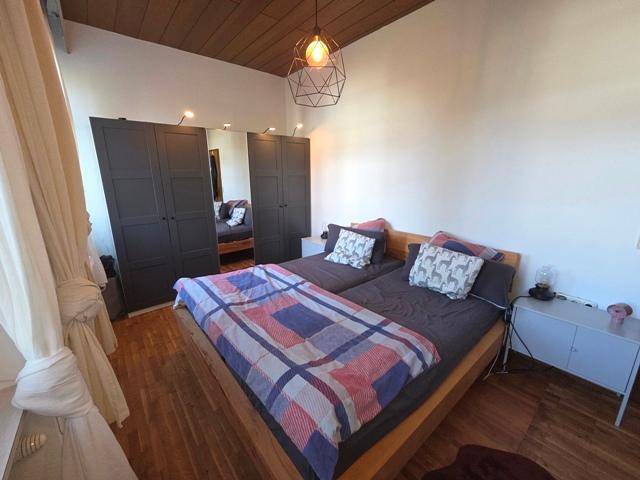 Schlafzimmer mit zwei Einzelbetten, Holzboden und Einbauschränken.