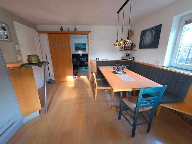 Gemütlicher Essbereich in der Küche mit Holztisch und Zugang zum angrenzenden Wohnzimmer.
