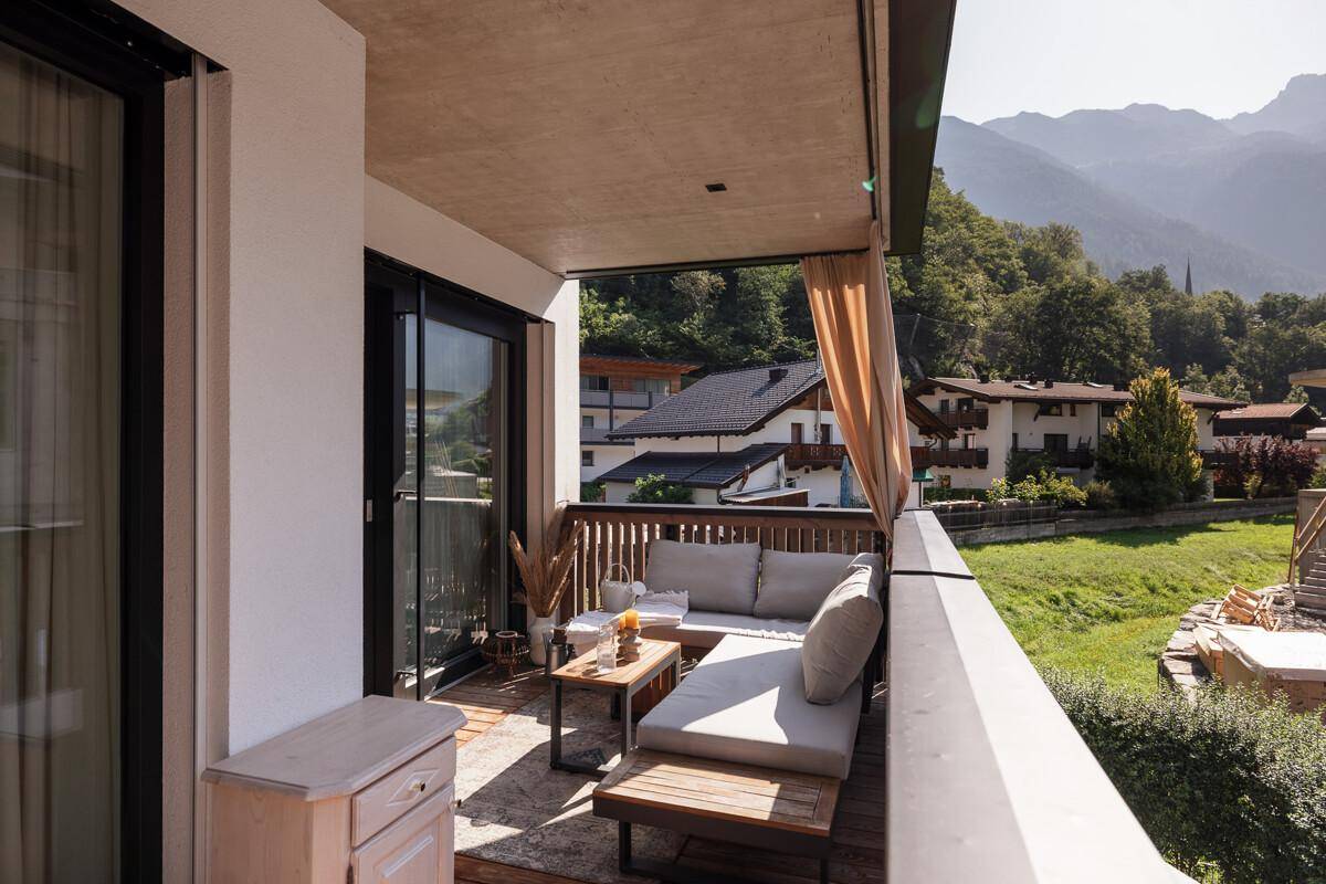 Gemütlicher Balkon mit Sitzgelegenheiten und einem malerischen Blick auf die umliegenden Berge.