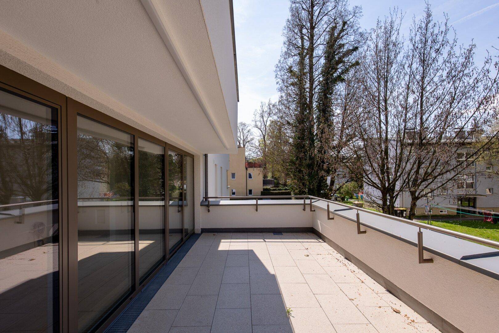 Geräumiger Balkon mit Fliesenboden und Blick ins Grüne, ideal zum Entspannen.