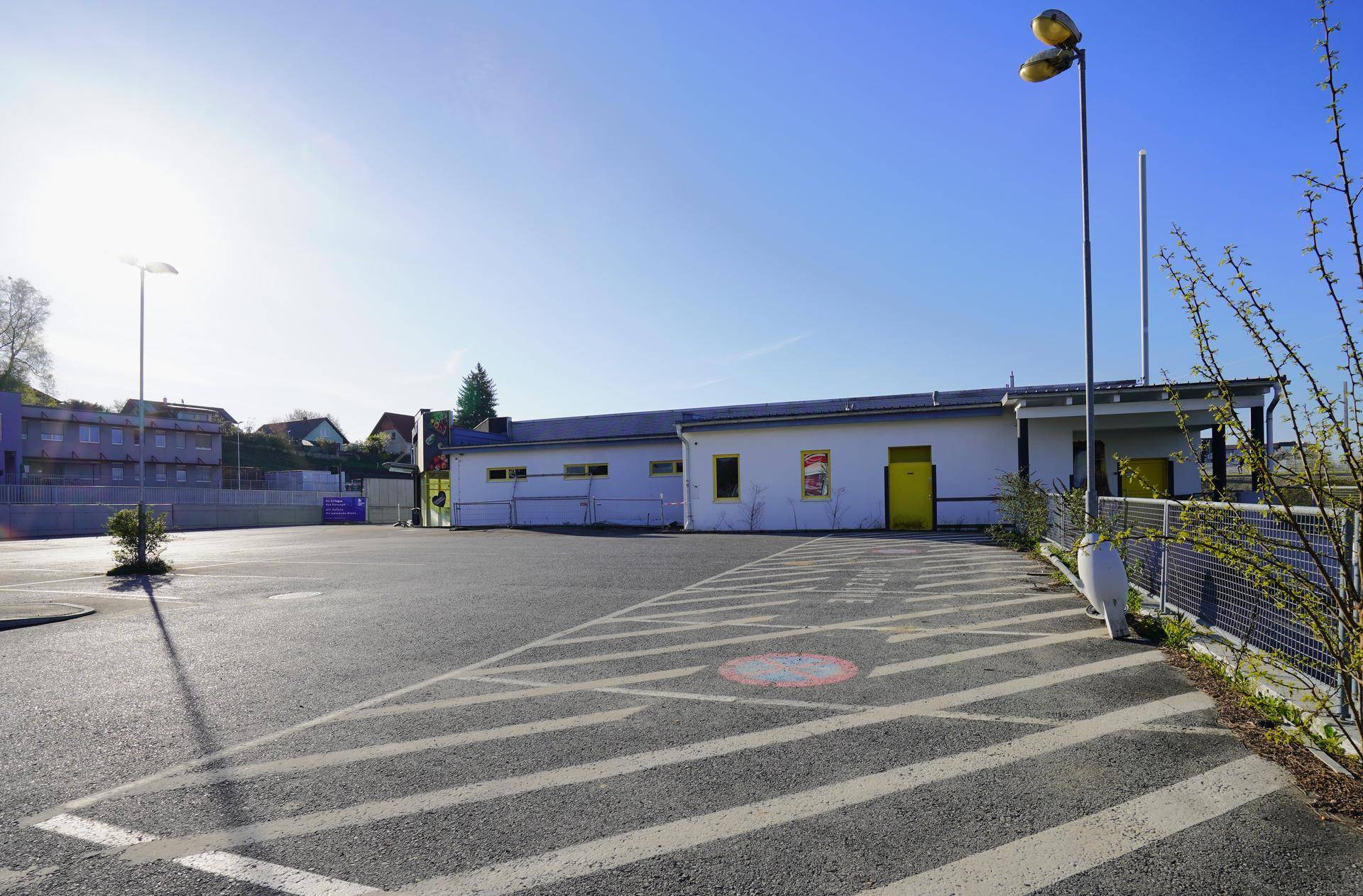Seitenansicht des Gebäudes mit weitem Parkplatz und sonnigem Wetter.