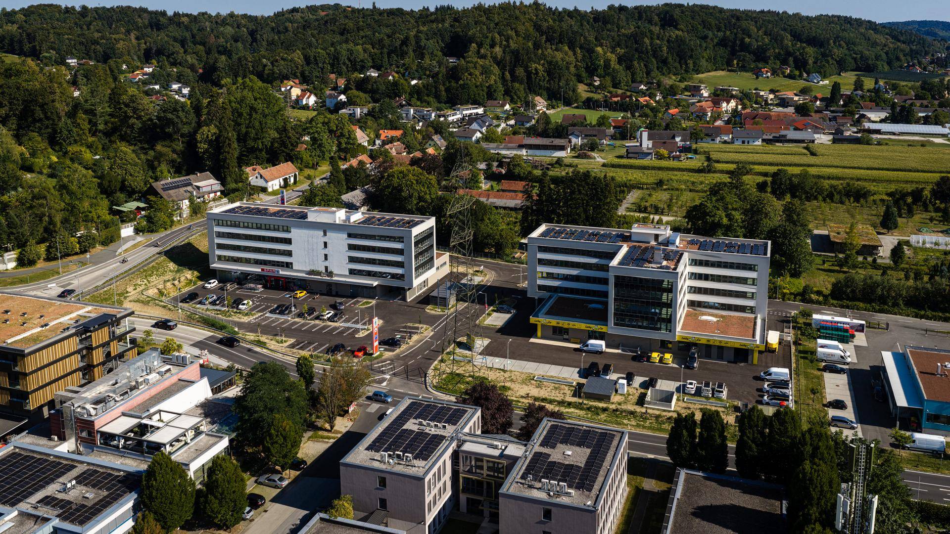 Weitläufige Luftaufnahme der modernen Gebäude in einer grünen Wohngegend mit Solaranlagen auf den Dächern.