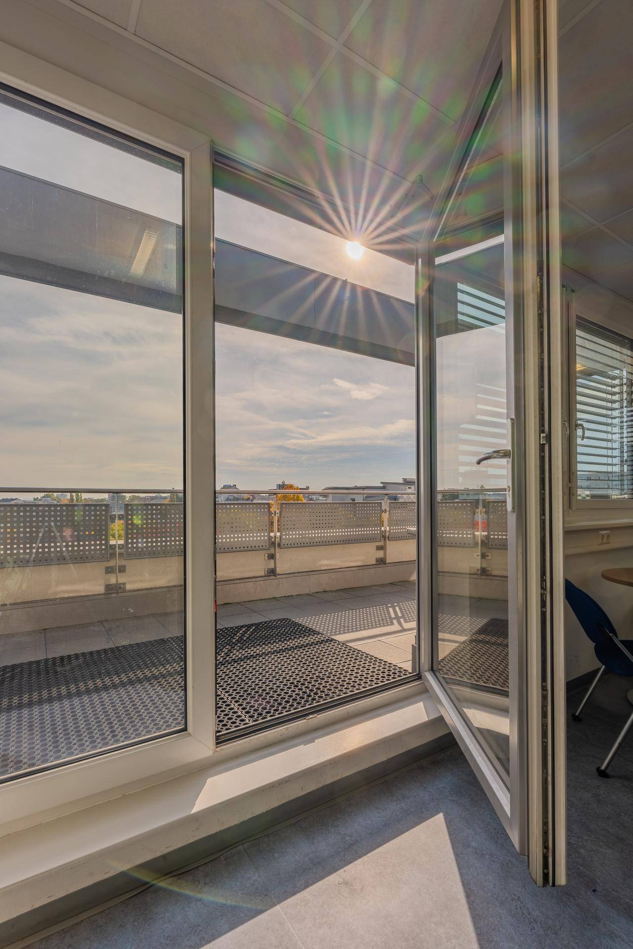 Sonnige Dachterrasse mit weitem Blick über die Stadt und die umliegende Landschaft.