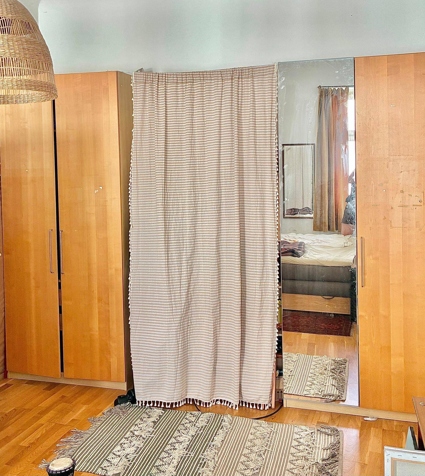 Schlafzimmer mit Holzboden, großen Kleiderschränken und einem Spiegel, der den Raum optisch vergrößert.