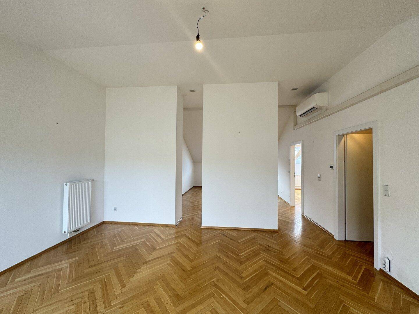 Großzügiger Wohnbereich mit Parkettboden und Klimaanlage, ideal für warme Sommertage.