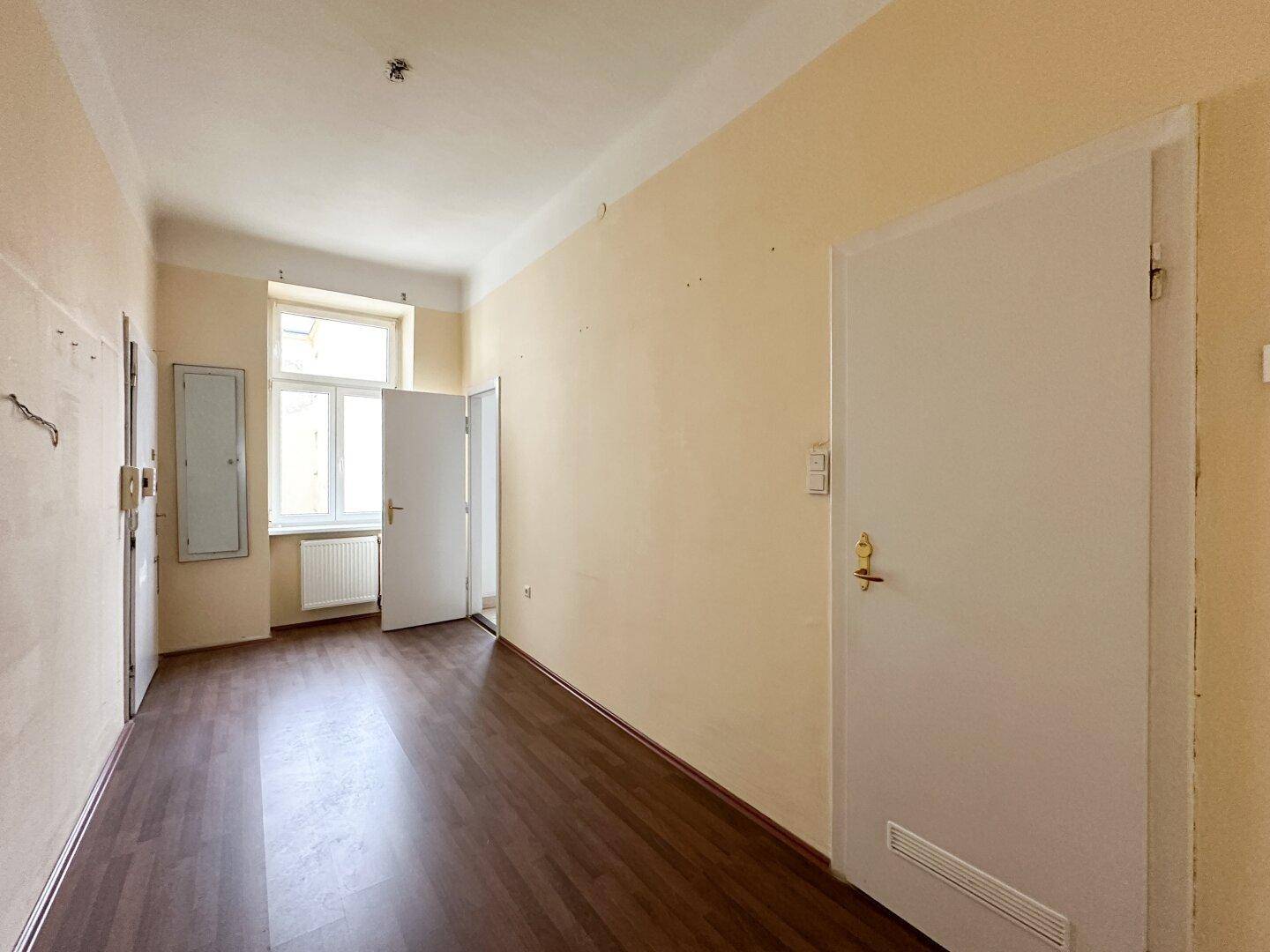 Heller Flur mit Laminatboden und mehreren Türen zu angrenzenden Räumen.