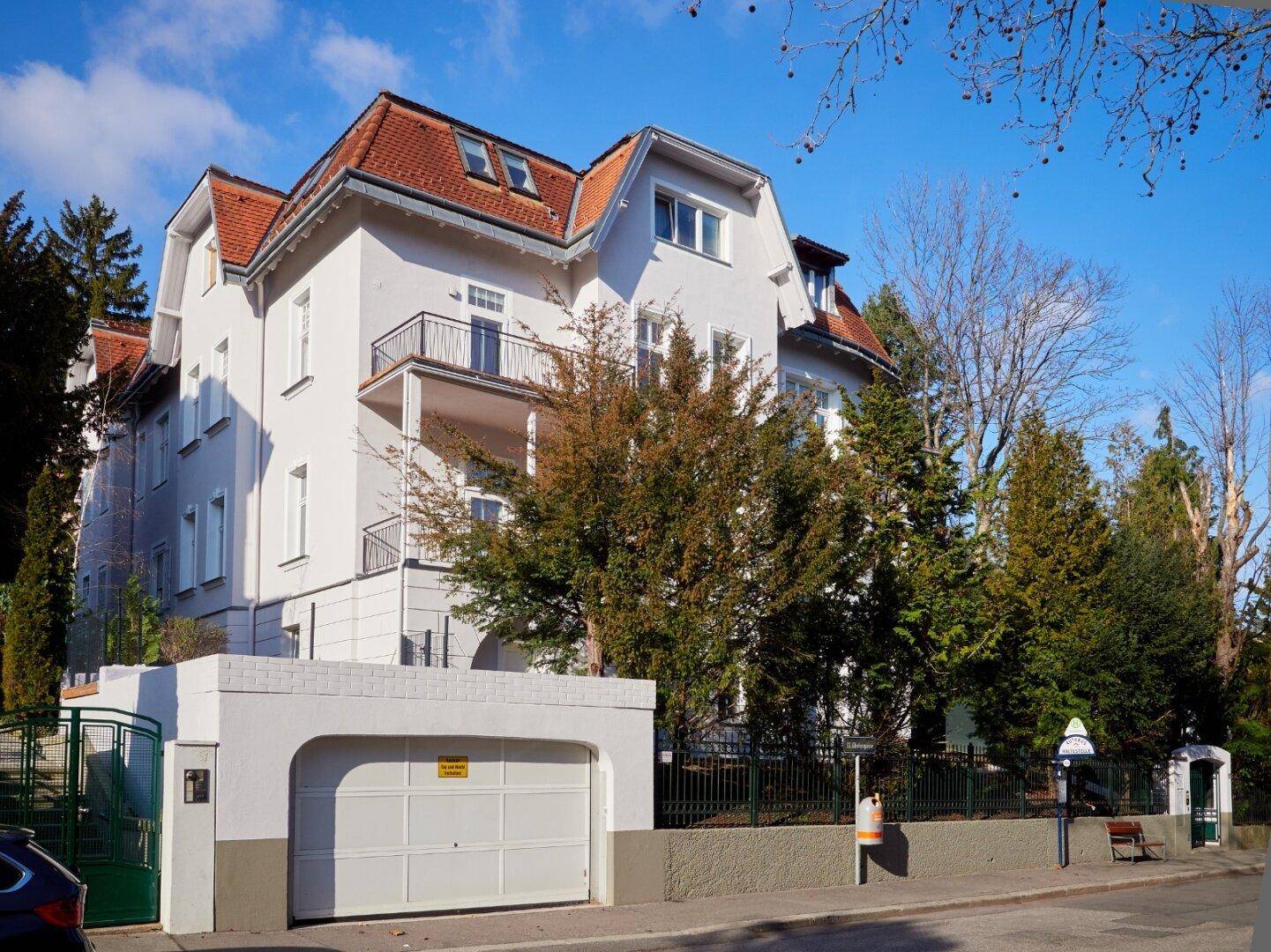 Repräsentative Stadtvilla mit Garage, Balkonen und gepflegter Außenanlage.