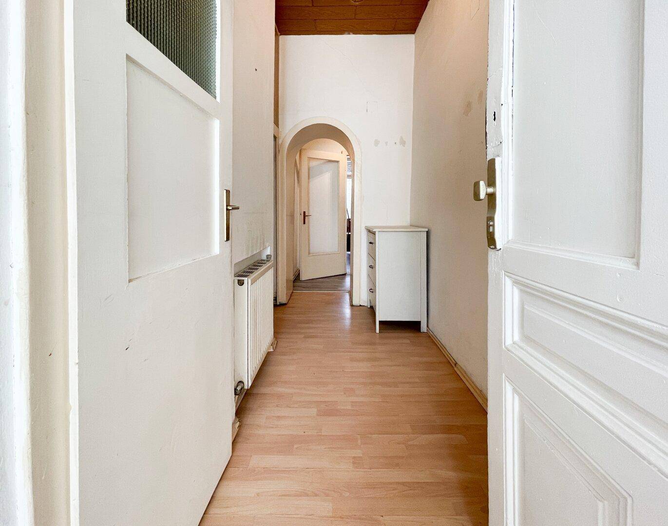Heller Flur mit Laminatboden, Holzdecke und Zugang zu weiteren Räumen, der gut gepflegt ist.