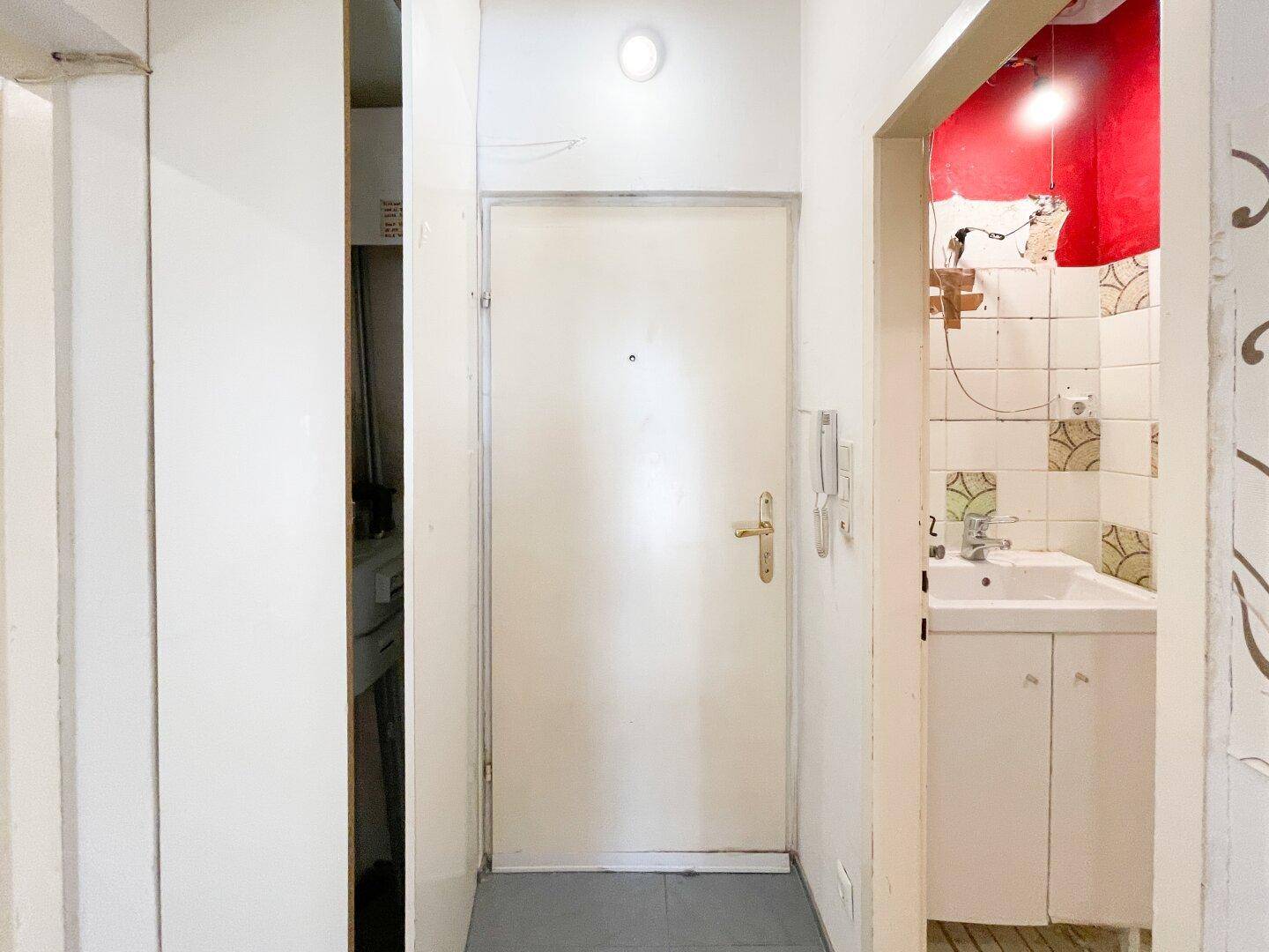 Eingangsbereich mit Haustür und Blick auf ein kleines Badezimmer oder Gäste-WC.