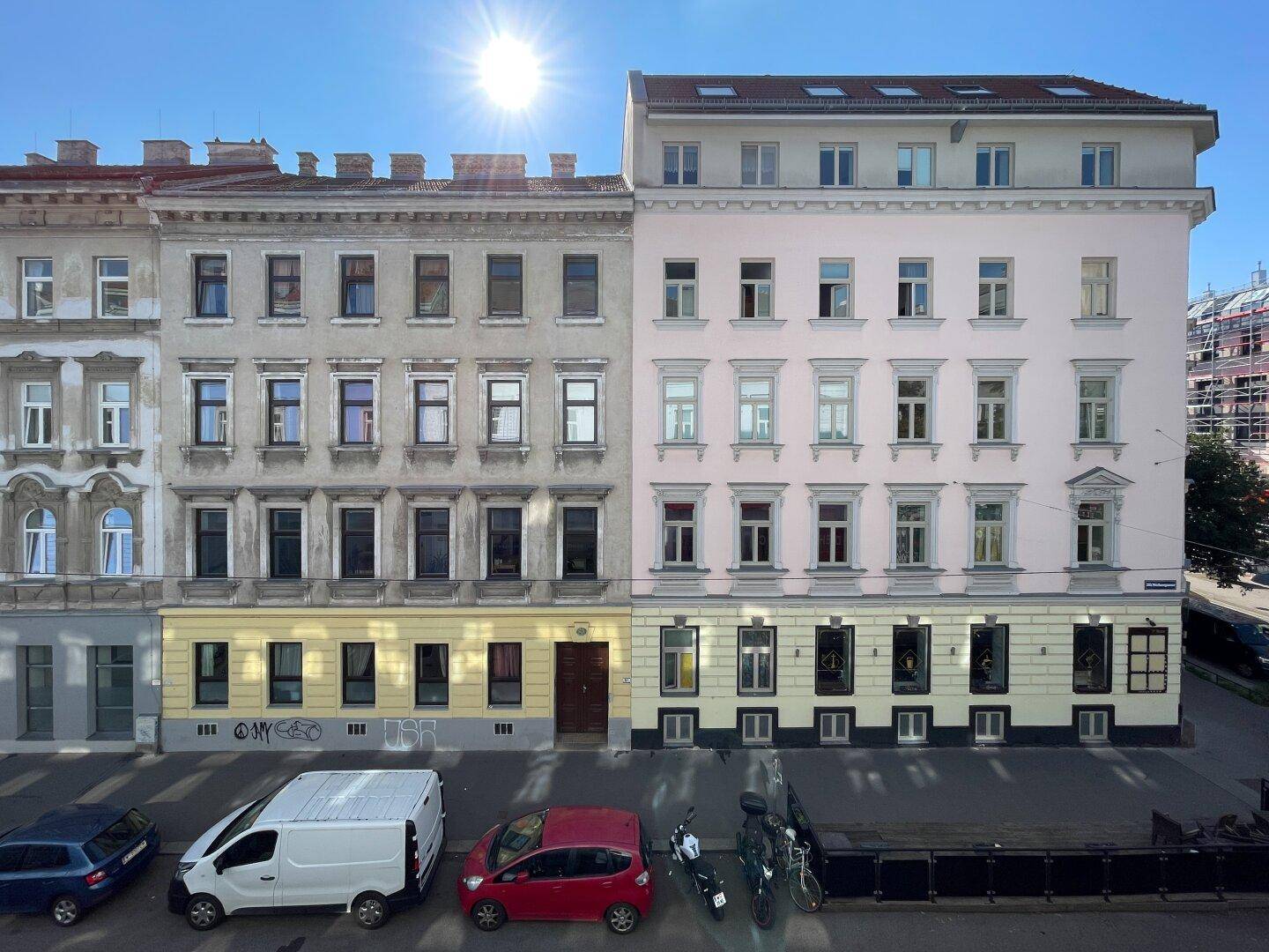 Historische Fassade eines Altbaus mit vielen Fenstern und Blick auf die Straße.