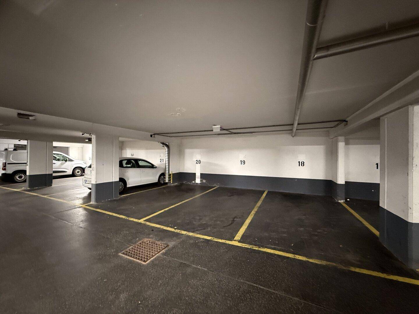 Geräumige Tiefgarage mit zahlreichen markierten Parkplätzen und guter Beleuchtung.