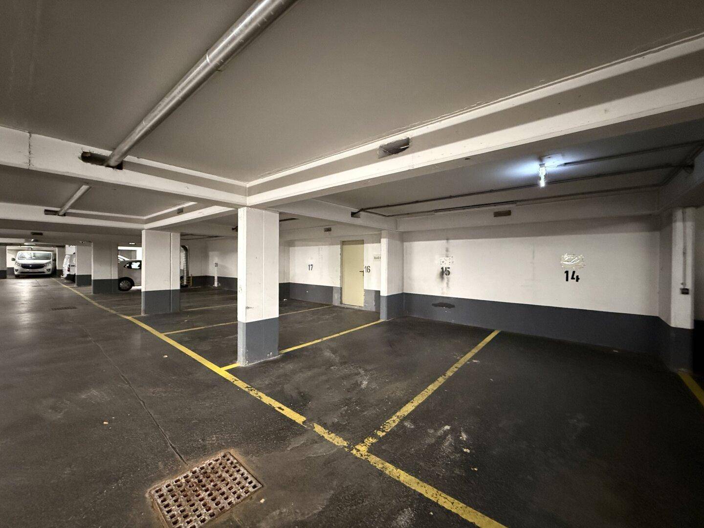 Weitläufige Tiefgarage mit vielen freien Stellplätzen und klarer Markierung auf dem Boden.