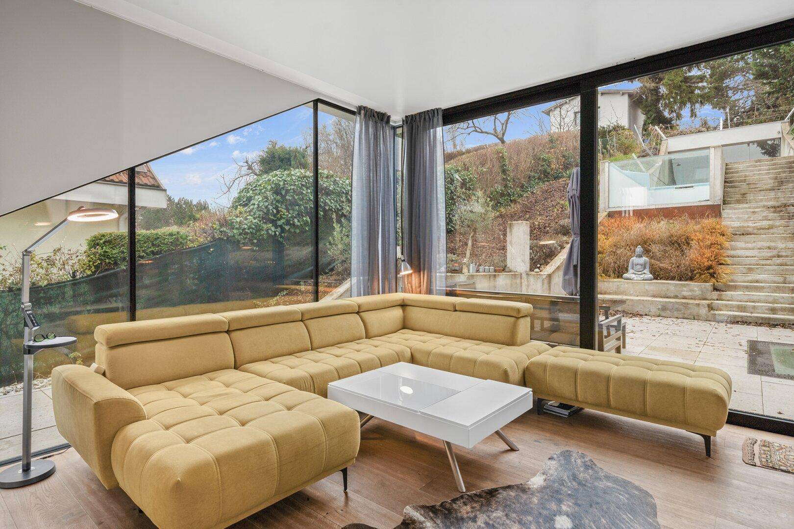Helles Wohnzimmer mit großzügigen Fenstern, die einen direkten Blick auf den Garten bieten.
