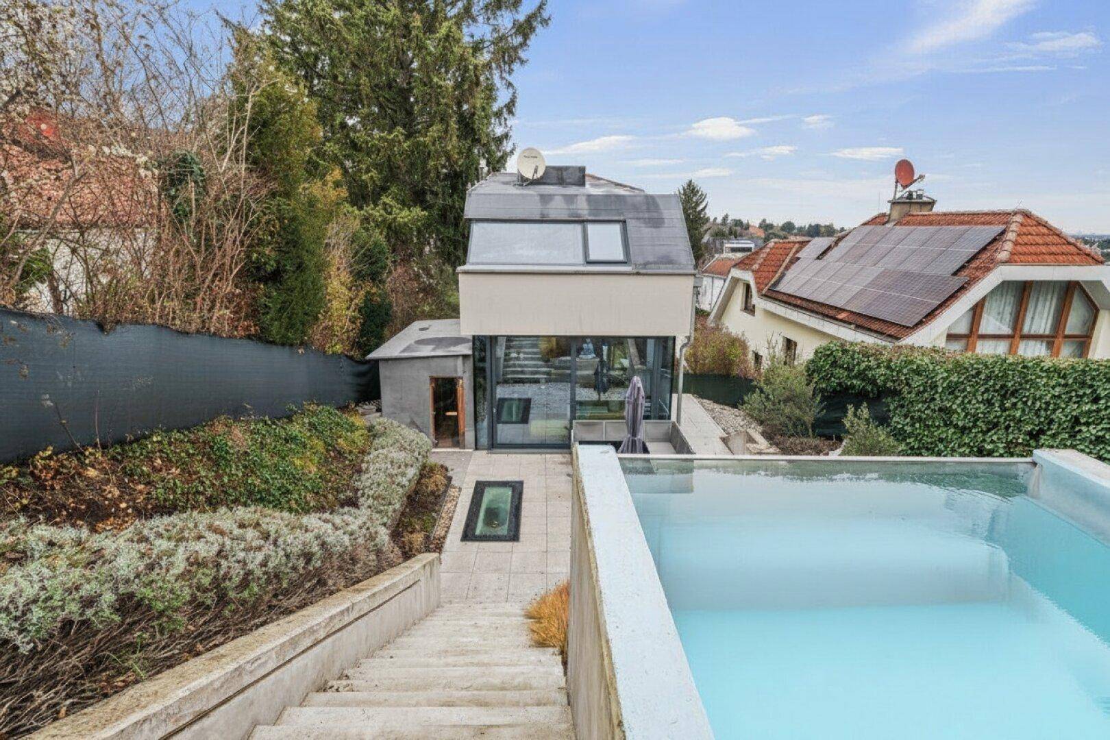 Ansicht des Hauses von oben mit Pool, Treppen und terrassiertem Garten.
