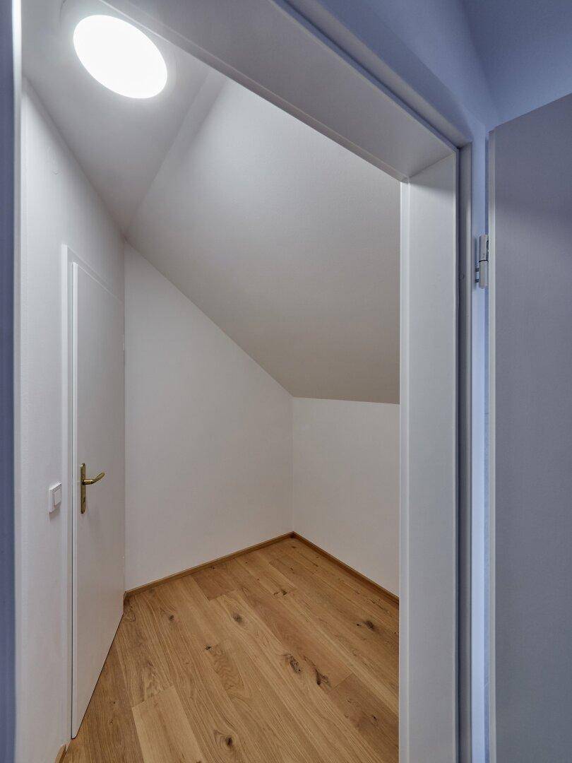 Praktischer Abstellraum mit Holzboden und Dachschräge, bietet zusätzlichen Stauraum.