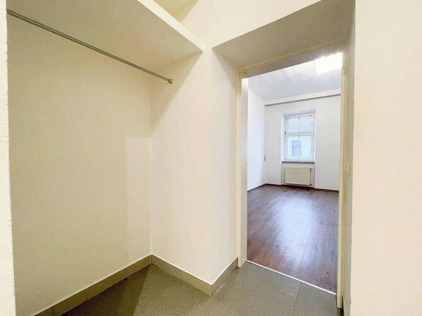 Praktischer Abstellraum mit Regalsystem und Zugang zu einem weiteren Zimmer.