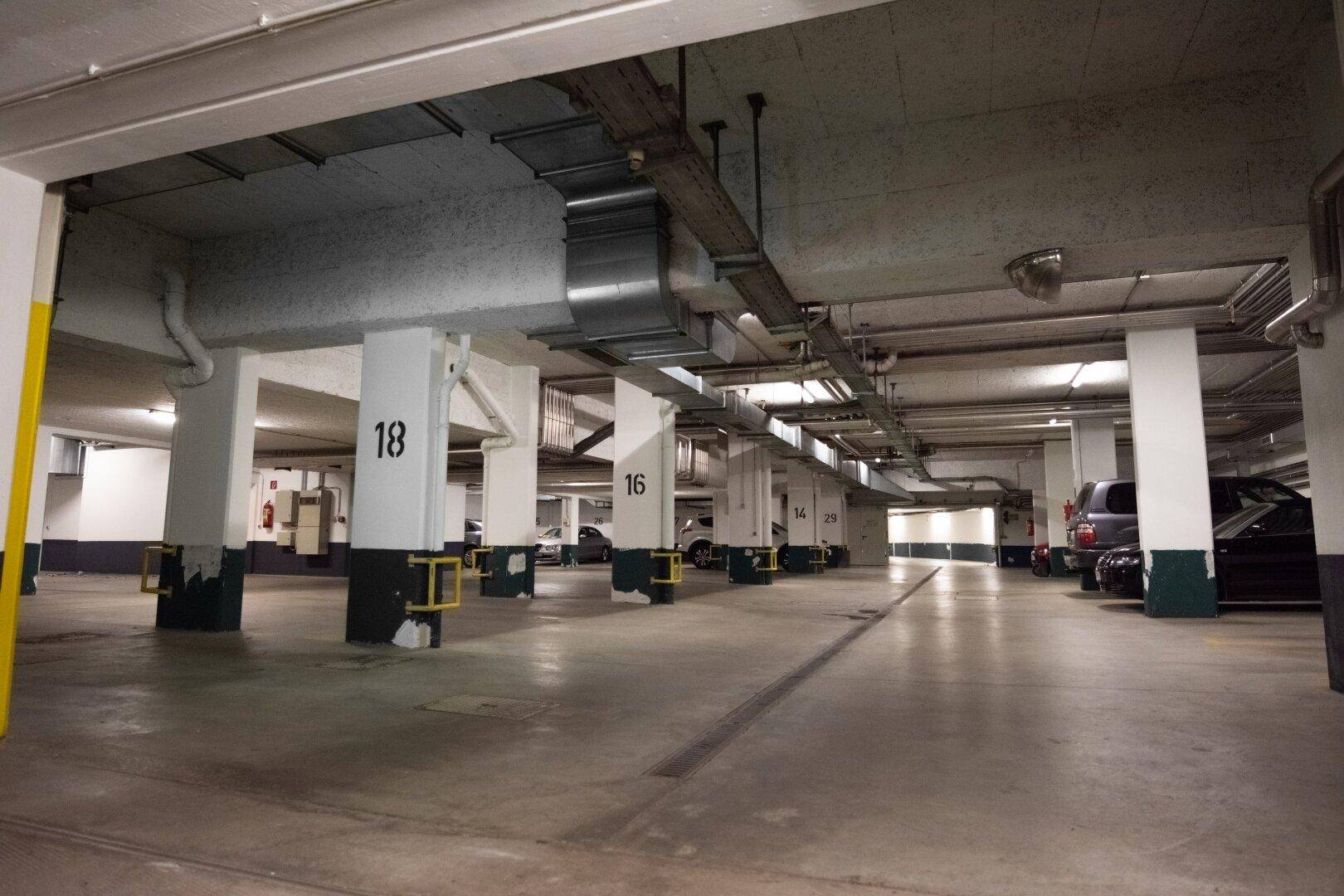 Geräumige Tiefgarage mit vielen Stellplätzen und klar gekennzeichneten Säulen.