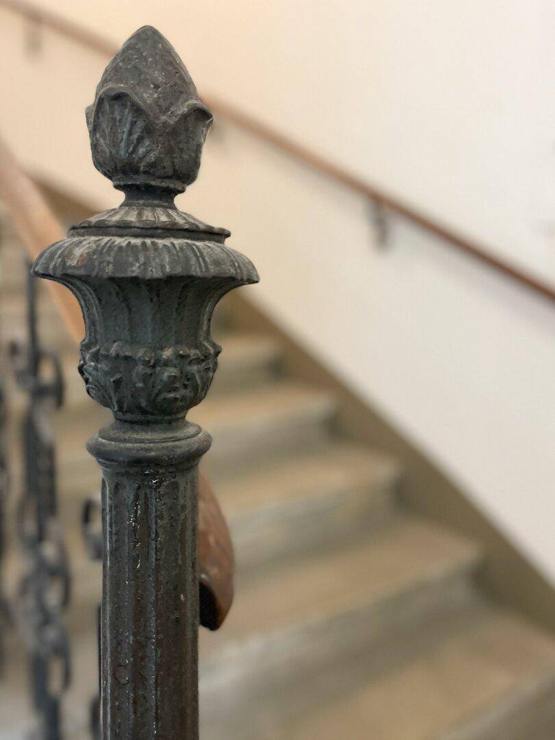 Detail des kunstvollen schmiedeeisernen Geländers im historischen Treppenhaus.