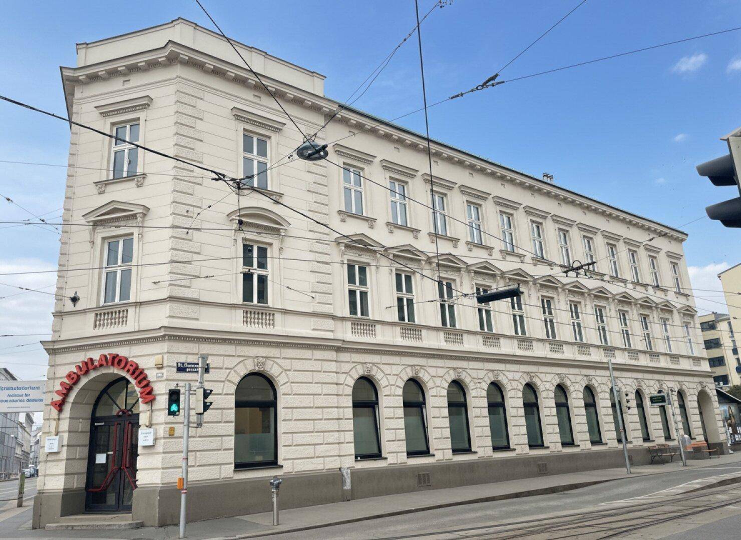 Elegantes Eckgebäude mit historischer Architektur und vielen Fenstern entlang der Straße.