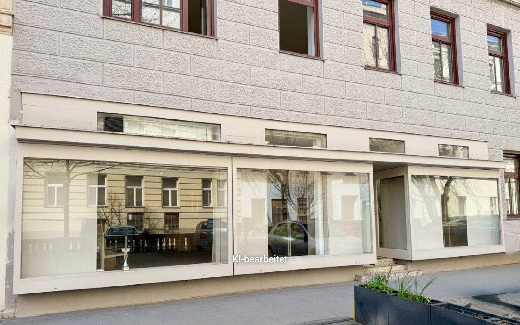 Detailansicht der Geschäftsfront im Erdgeschoss mit großen Schaufenstern und Blick auf die Straße.