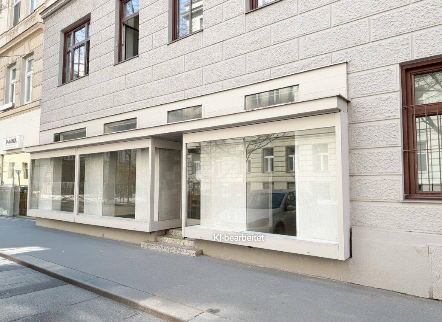 Seitenansicht der Geschäftsfläche im Erdgeschoss mit breiten Schaufenstern und Zugang von der Straße.