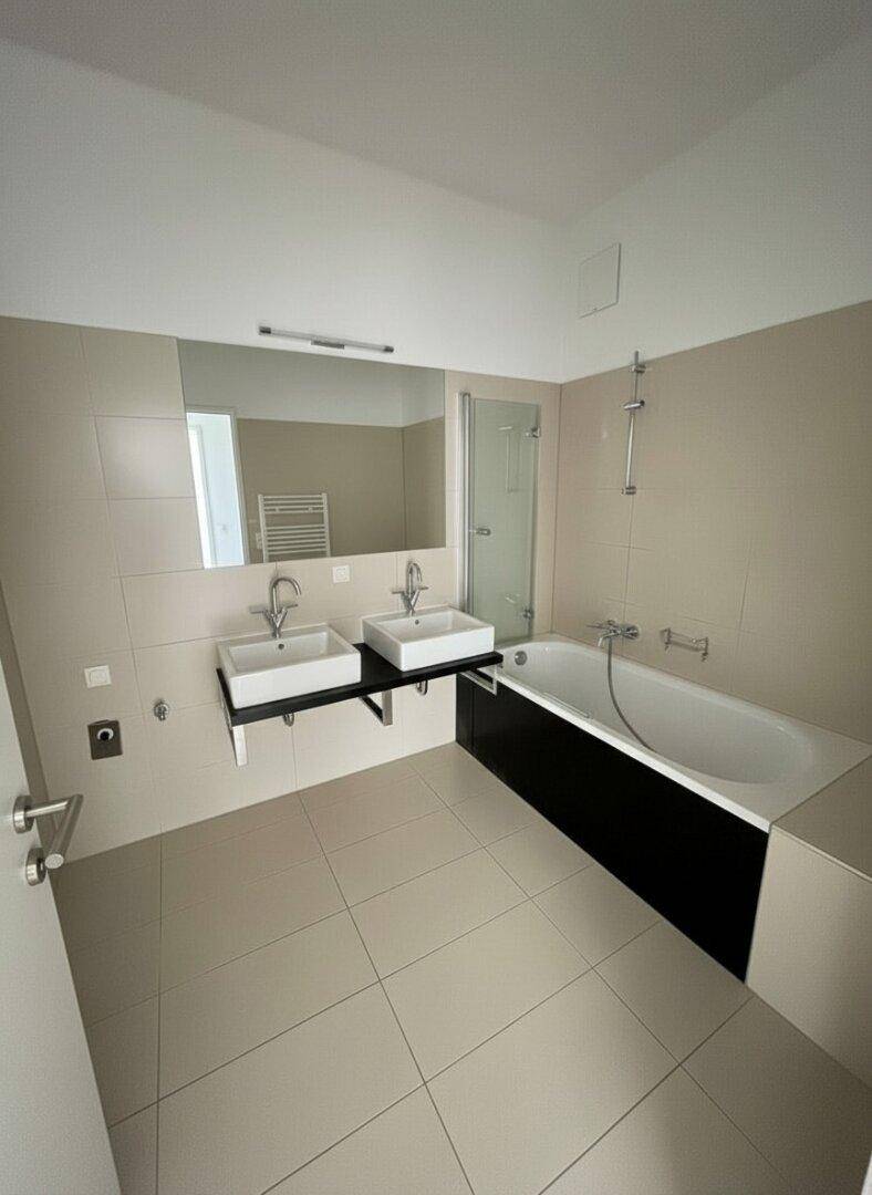 Modernes Badezimmer mit Doppelwaschbecken, Badewanne und separater Dusche.