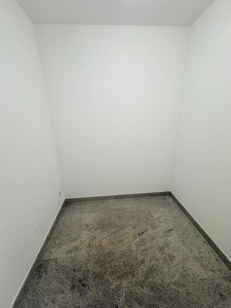 Kleiner Abstellraum mit robustem Steinboden, ideal für zusätzlichen Stauraum.