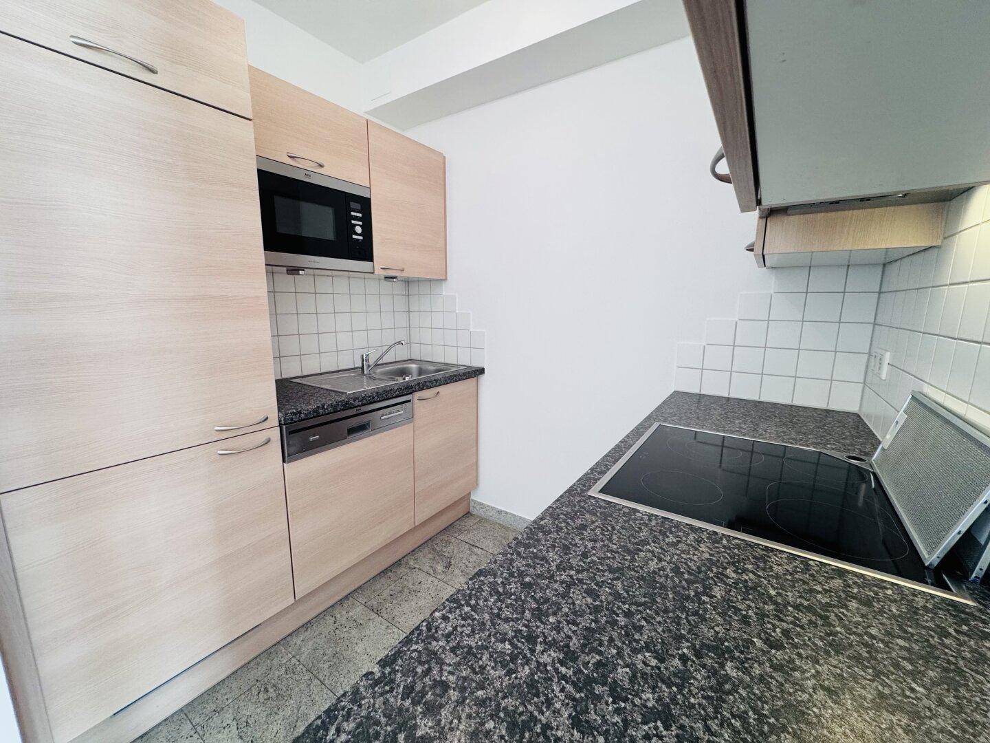 Moderne Einbauküche mit Holzfronten, Granitarbeitsplatte und integrierten Geräten.