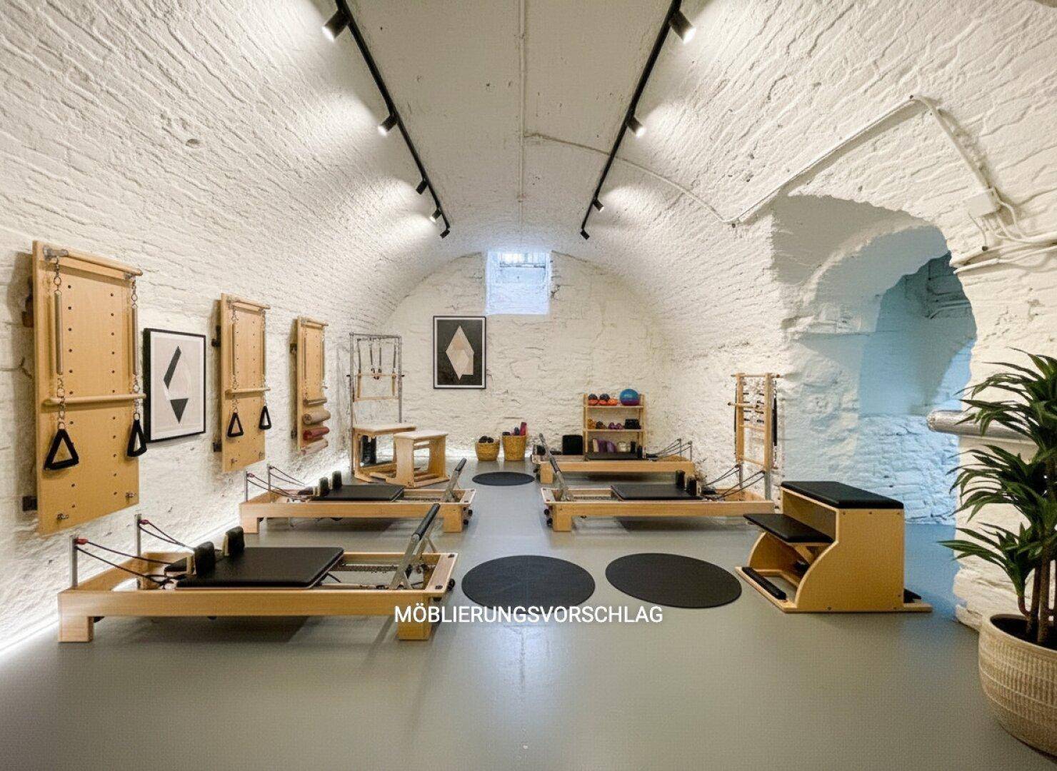 Einzigartiger Fitnessraum im Gewölbekeller mit Pilates-Geräten und weiß gestrichenen Steinwänden.