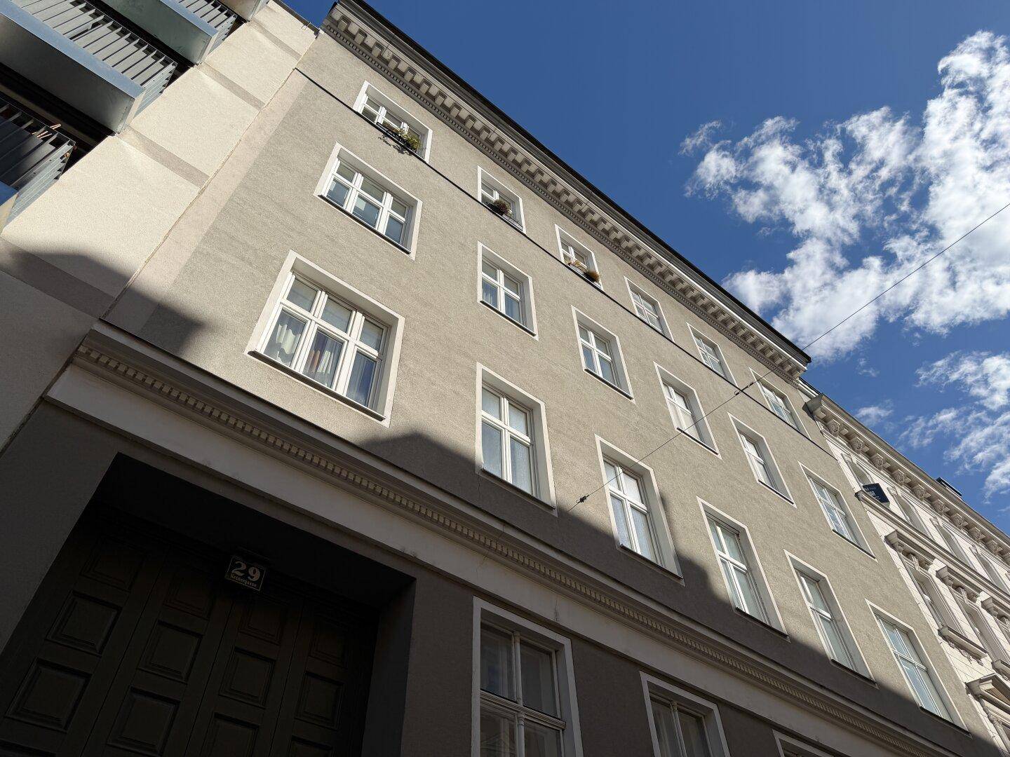 Ansicht der Gebäudefassade mit vielen Fenstern unter blauem Himmel.