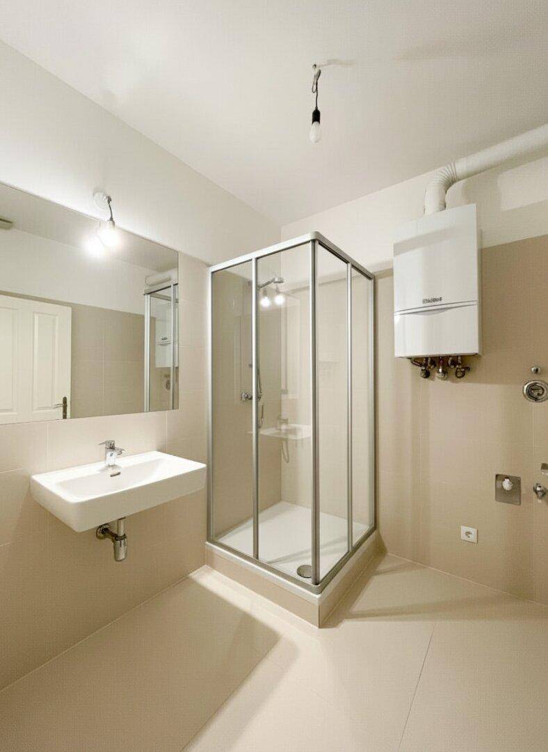 Modernes Badezimmer mit Duschkabine, Waschbecken und Gastherme an der Wand.