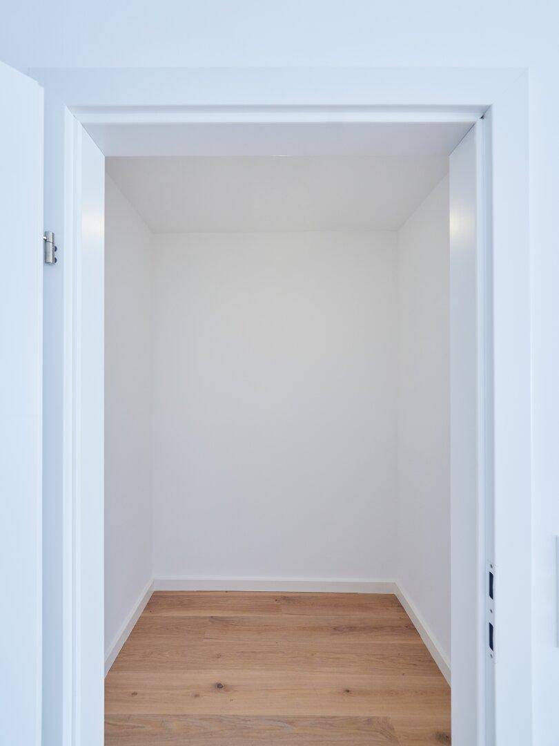 Kleiner Abstellraum mit Holzboden und weißen Wänden, ideal für zusätzlichen Stauraum.