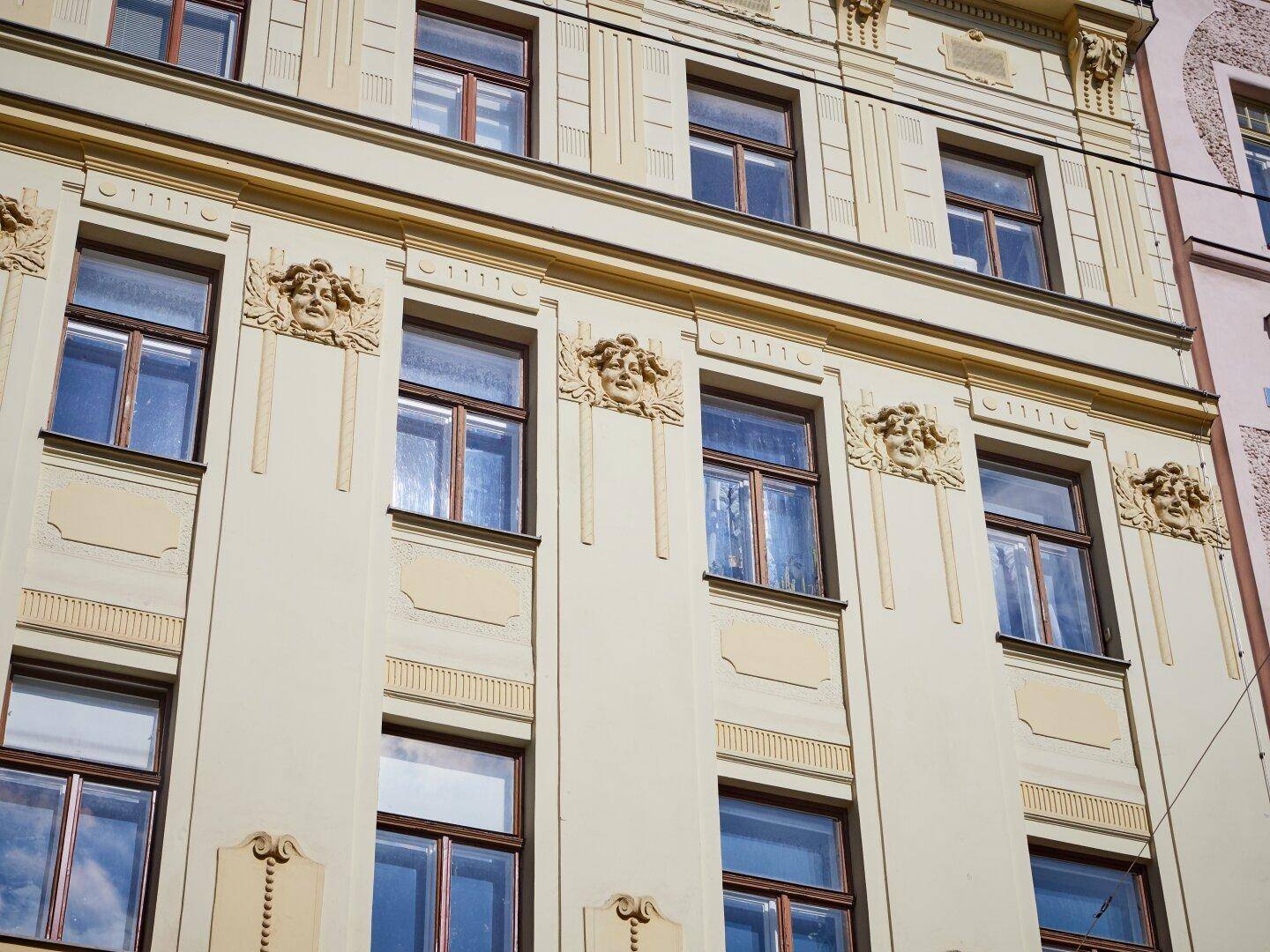 Detailansicht der historischen Fassade mit kunstvollen Verzierungen und Fenstern.