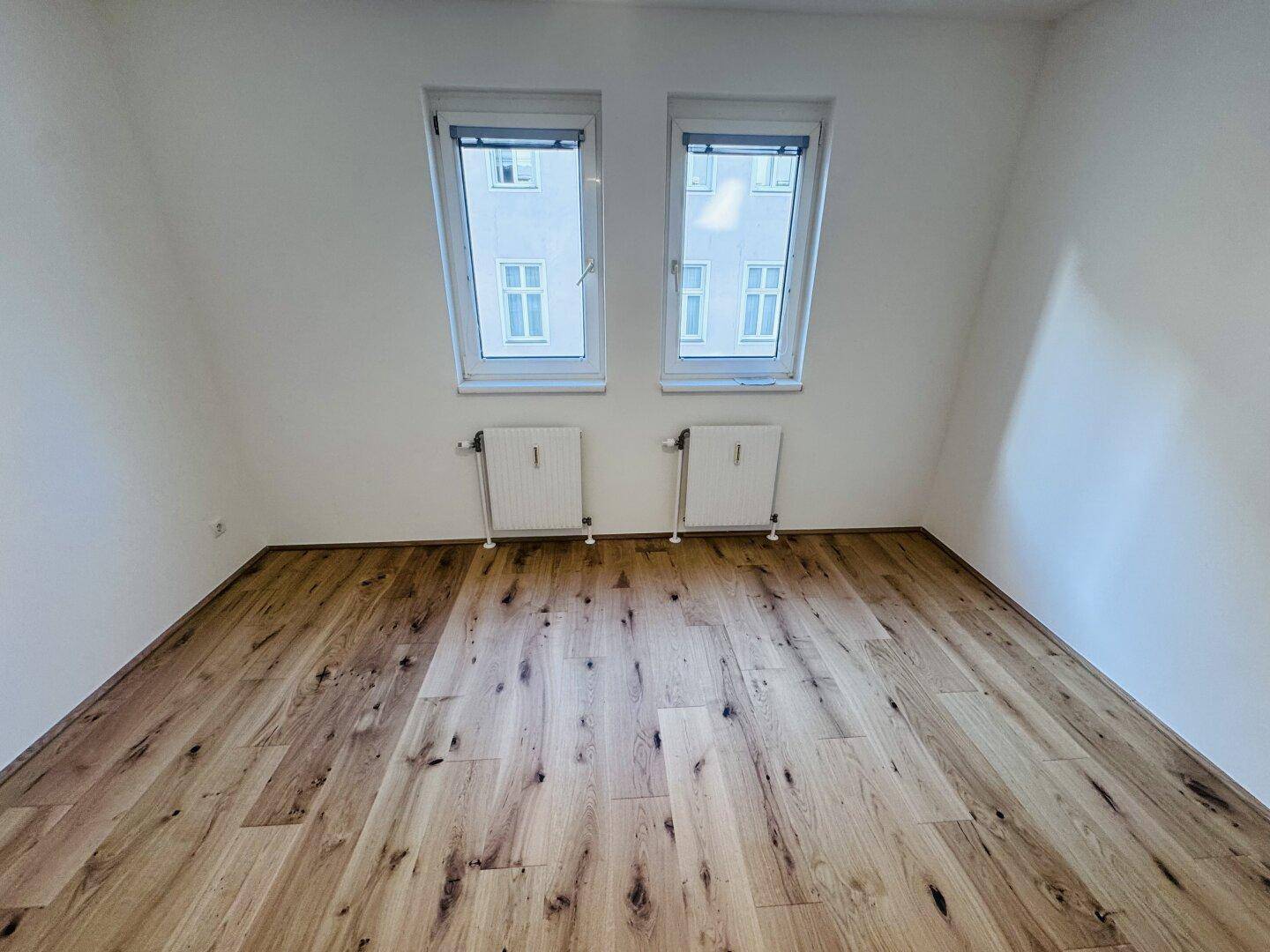 Helles Schlafzimmer mit Holzboden und Dachfenstern, bietet eine gemütliche Atmosphäre.