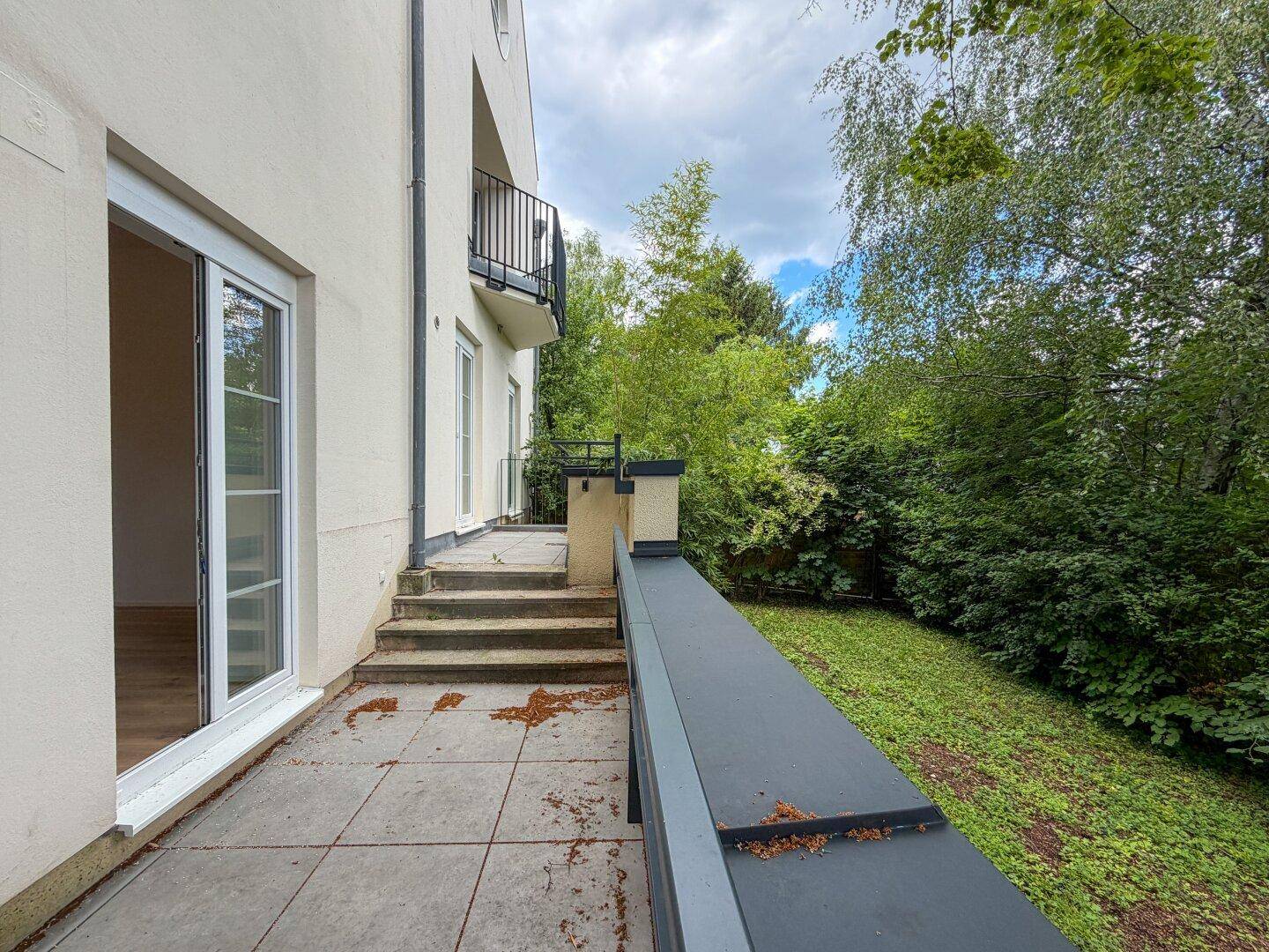 Terrasse mit Zugang zum Garten und Blick auf die grüne Umgebung des Hauses.