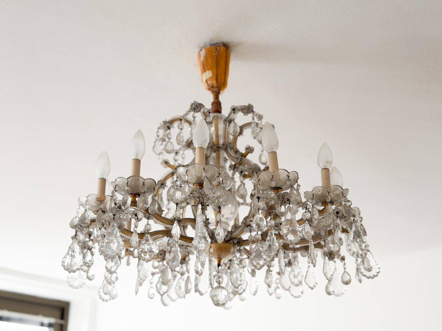 Detailaufnahme eines opulenten Kronleuchters mit vielen Kristallen, der Eleganz verleiht.