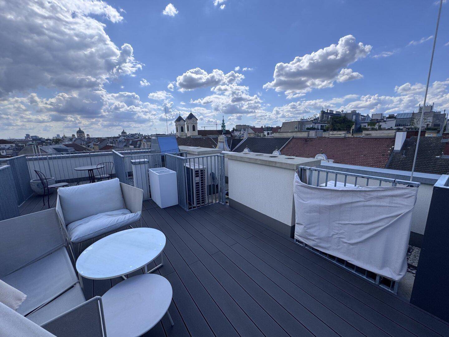 Weitläufige Dachterrasse mit bequemen Sitzgelegenheiten und beeindruckendem Stadtpanorama.