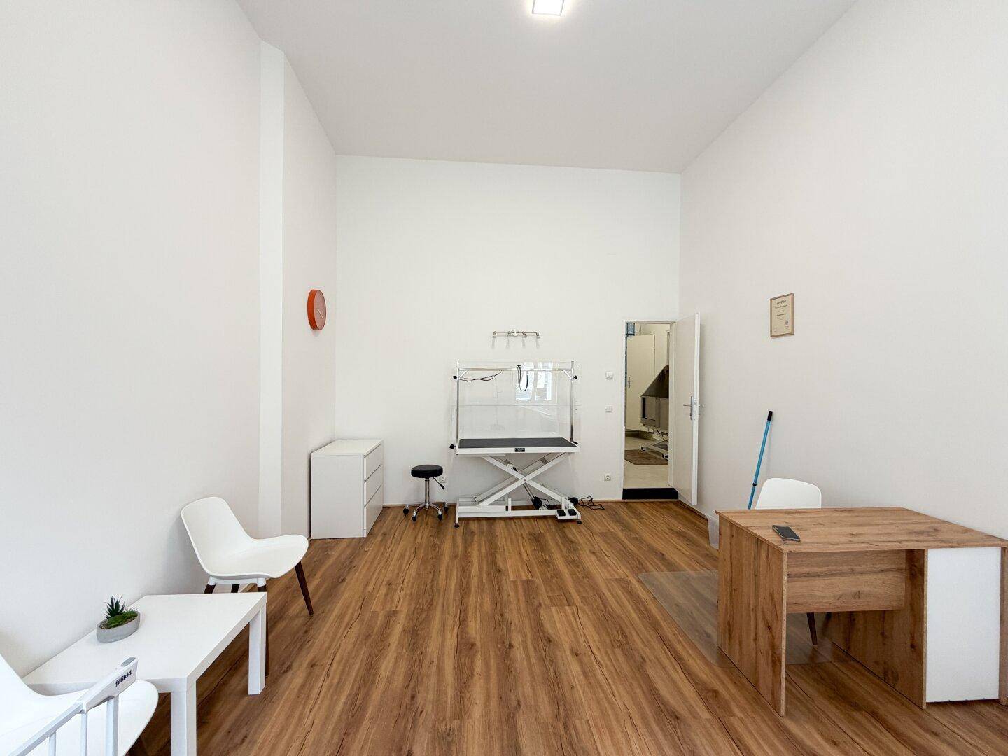 Langer Geschäftsraum mit Schreibtisch, Stühlen und einem Arbeitstisch, ideal für verschiedene Dienstleistungen.