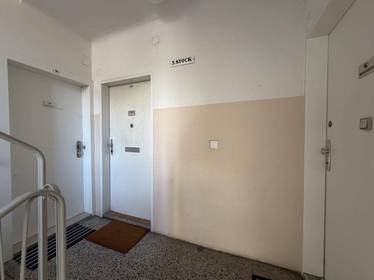 Treppenhausflur mit mehreren Wohnungstüren und einem Hinweis auf die dritte Etage.