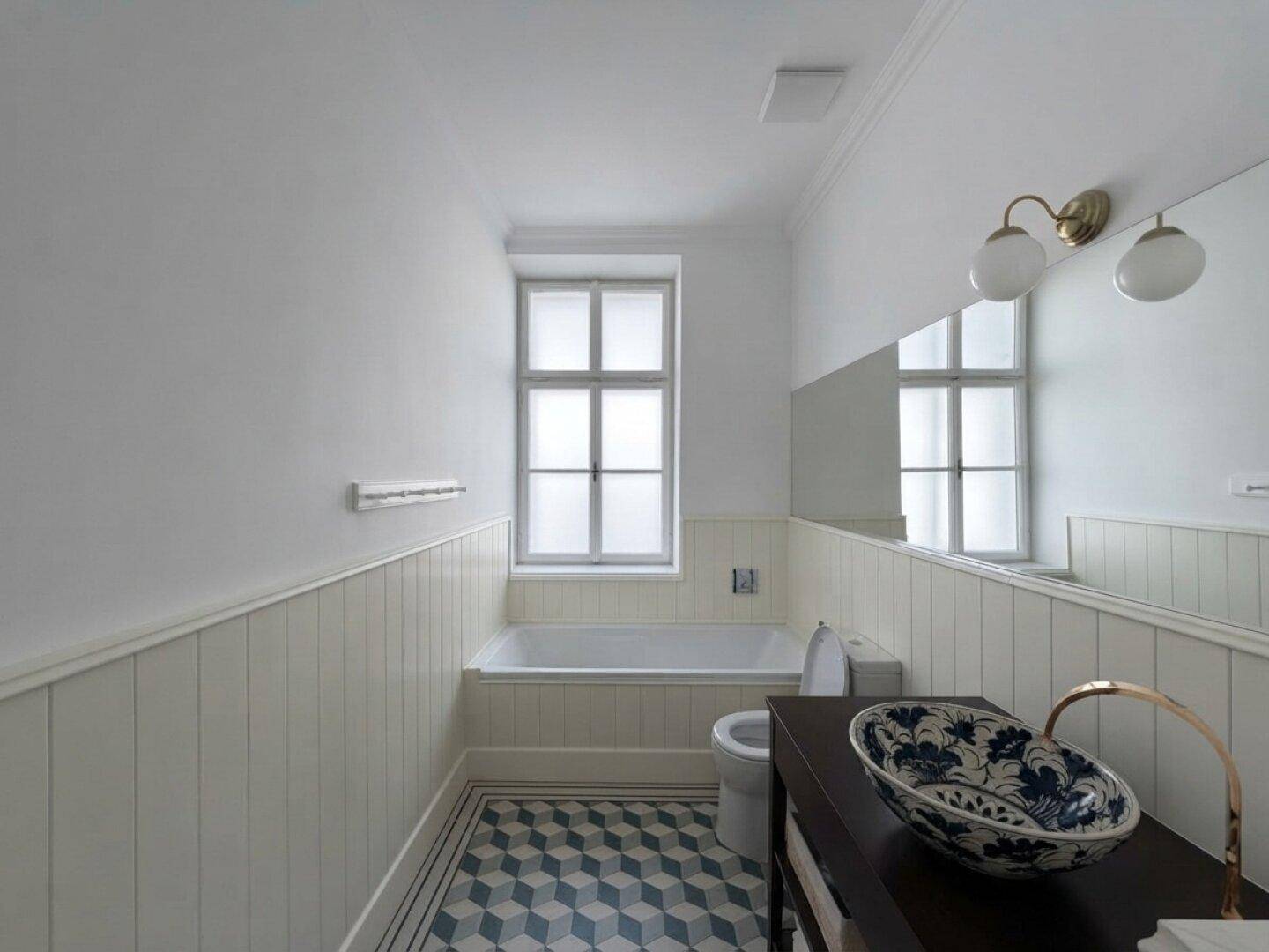 Modernes Badezimmer mit Badewanne, Fenster und geometrischem Fliesenboden.